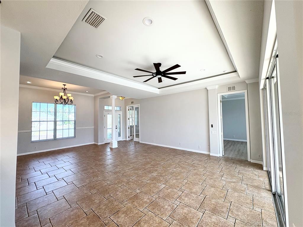 An open-concept living area features a tray ceiling, tile flooring, and a ceiling fan — 2910 122ND TERRACE E, PARRISH, FL