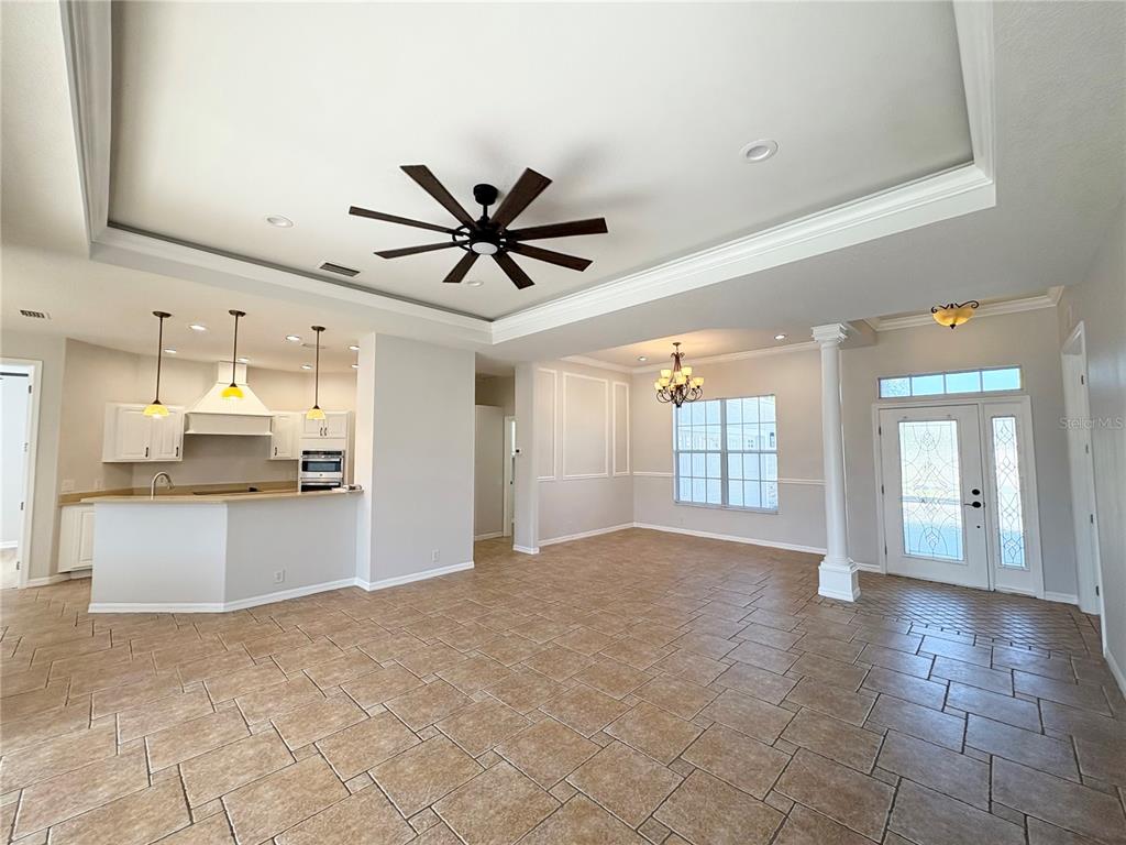 An open-concept living and kitchen area features tile flooring, a tray ceiling, and a column — 2910 122ND TERRACE E, PARRISH, FL