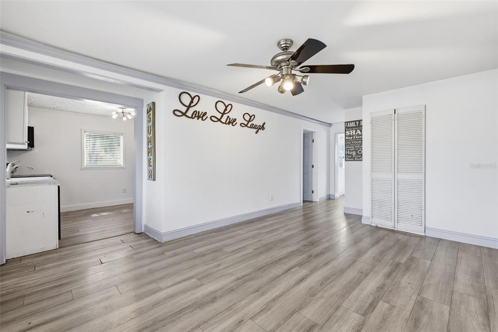An empty room features light wood-look flooring, a ceiling fan, and white walls — 2706 E ANNIE STREET, TAMPA, FL