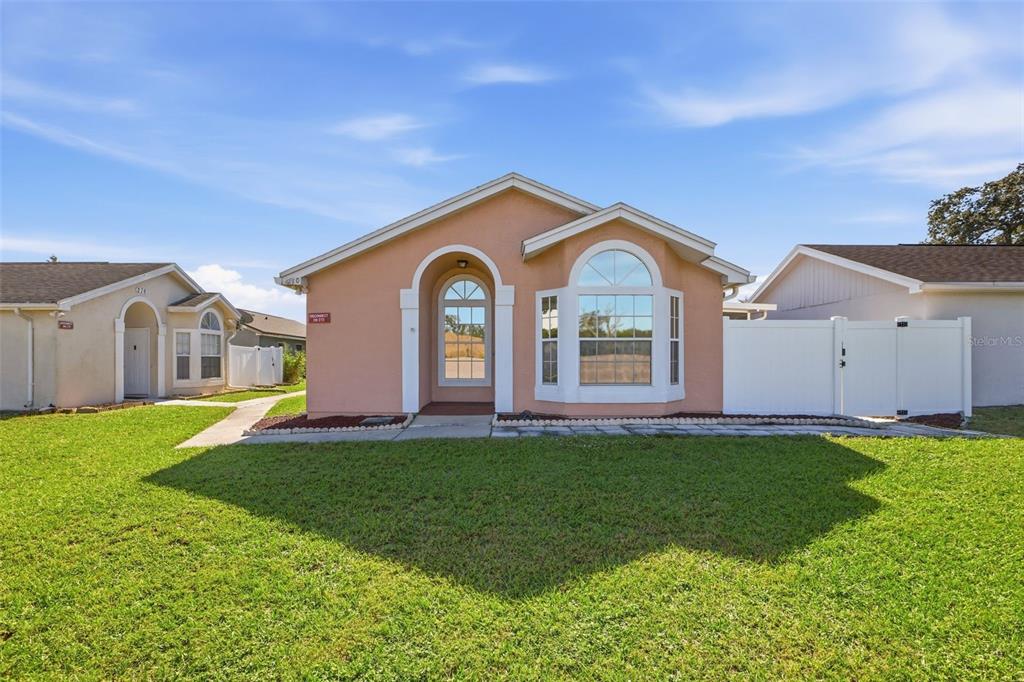 A single-story peach-colored house with a front porch, bay window, and white vinyl fence — 270 SAN GABRIEL STREET, WINTER SPRINGS, FL
