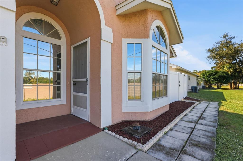 A peach-colored house exterior features a front entryway, a bay window, and a stone walkway — 270 SAN GABRIEL STREET, WINTER SPRINGS, FL