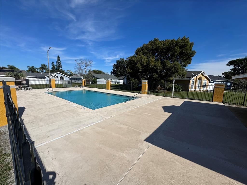 An outdoor swimming pool with a concrete deck is enclosed by a black metal fence — 270 SAN GABRIEL STREET, WINTER SPRINGS, FL