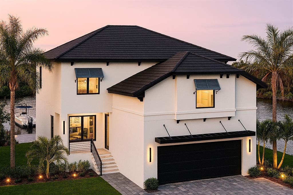 A two-story white house with a black roof and garage sits beside a waterway — 554 ESTUARY SHORE LANE, APOLLO BEACH, FL