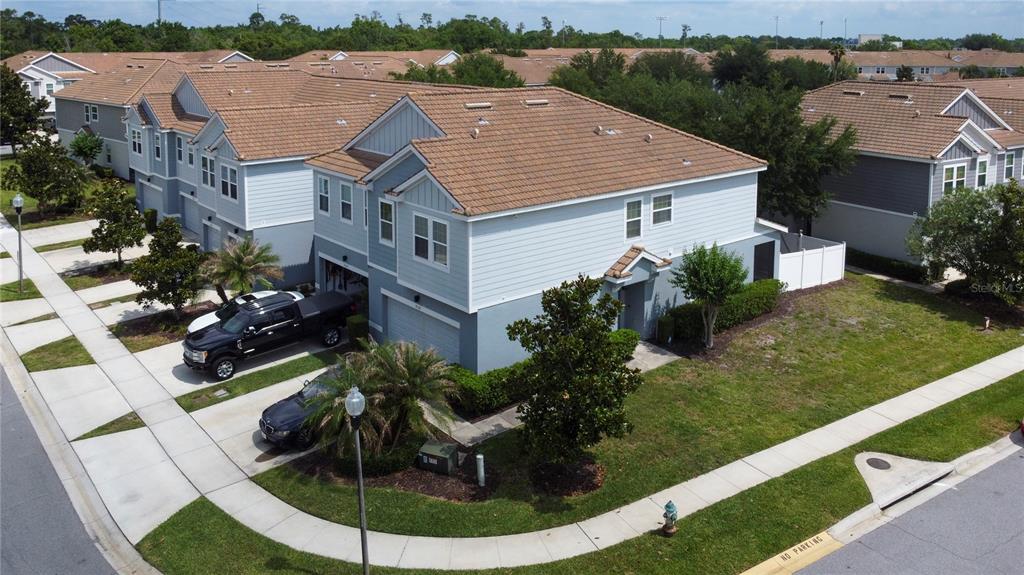 An aerial view of a two-story blue townhouse with a brown tile roof and driveway — 9118 SHEPTON STREET, ORLANDO, FL