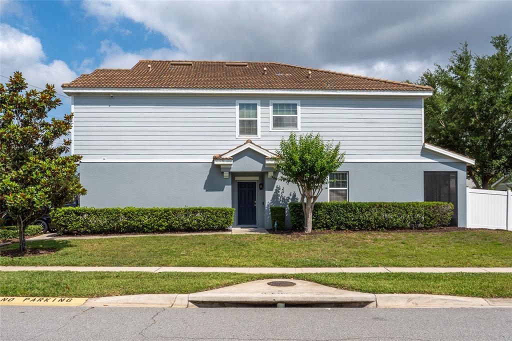 A two-story house with light blue siding, a dark door, and a manicured hedge — 9118 SHEPTON STREET, ORLANDO, FL