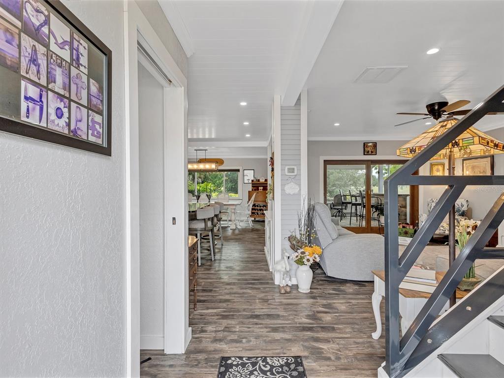 A view from a hallway looking into an open-concept living room and dining area — 7581 CUMBERLAND ROAD UNIT 7, SEMINOLE, FL