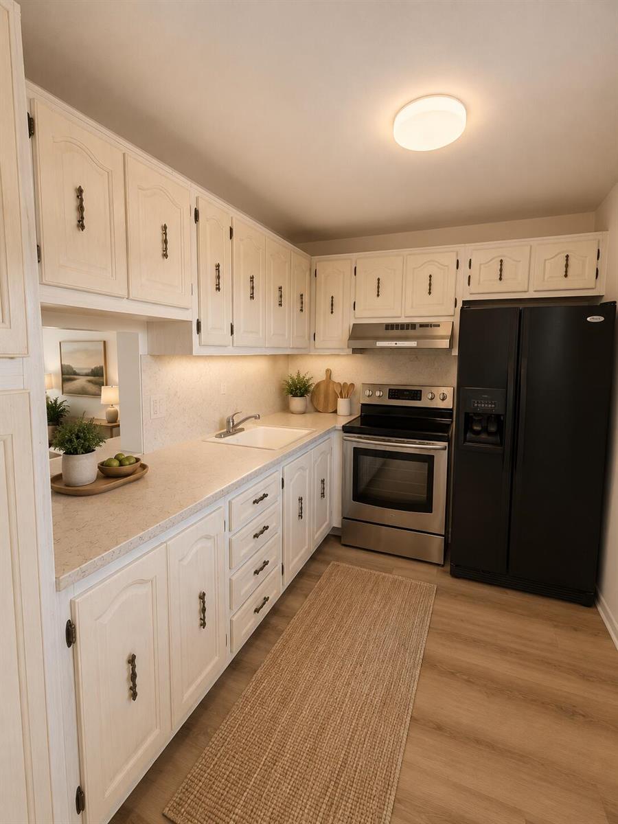 A kitchen features white cabinets, stainless steel appliances, a black refrigerator, and light-colored countertops — 130 NE 26th Avenue # 2030, Boynton Beach FL 33435, BOYNTON BEACH, FL
