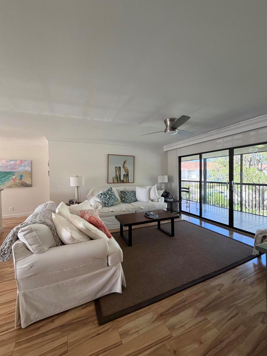 A living room features two white sofas, a dark coffee table, and sliding glass doors — 4607 Kittiwake Court # 2, Boynton Beach FL 33436, BOYNTON BEACH, FL