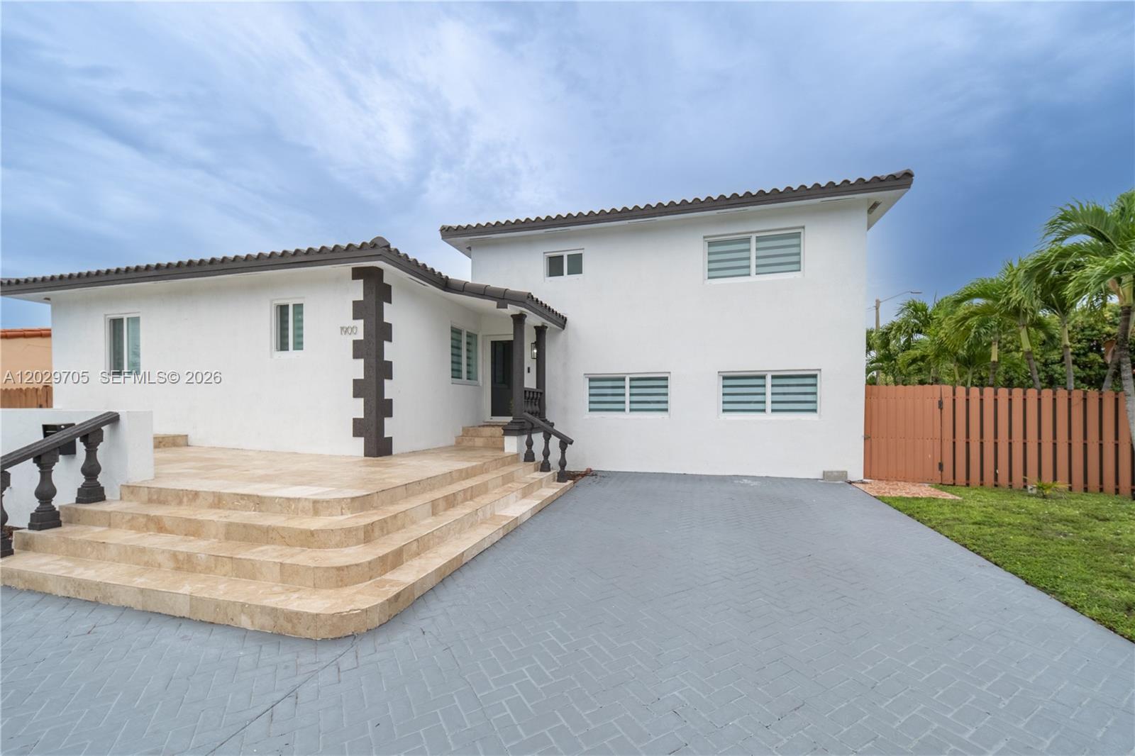 A white two-story house features a tiled front patio with steps and a paved driveway — 1900 SW 83rd Ave, Miami FL 33155, MIAMI, FL