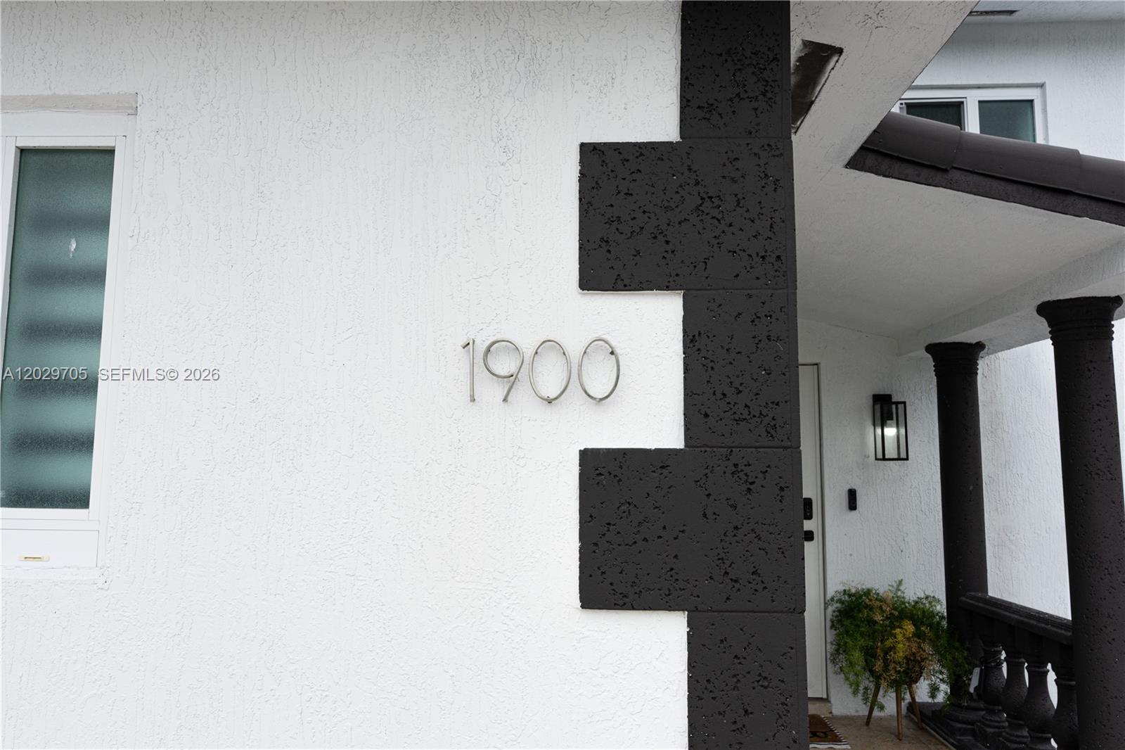 The exterior of a house features white stucco walls, black stone accents, and house number 1900 — 1900 SW 83rd Ave, Miami FL 33155, MIAMI, FL