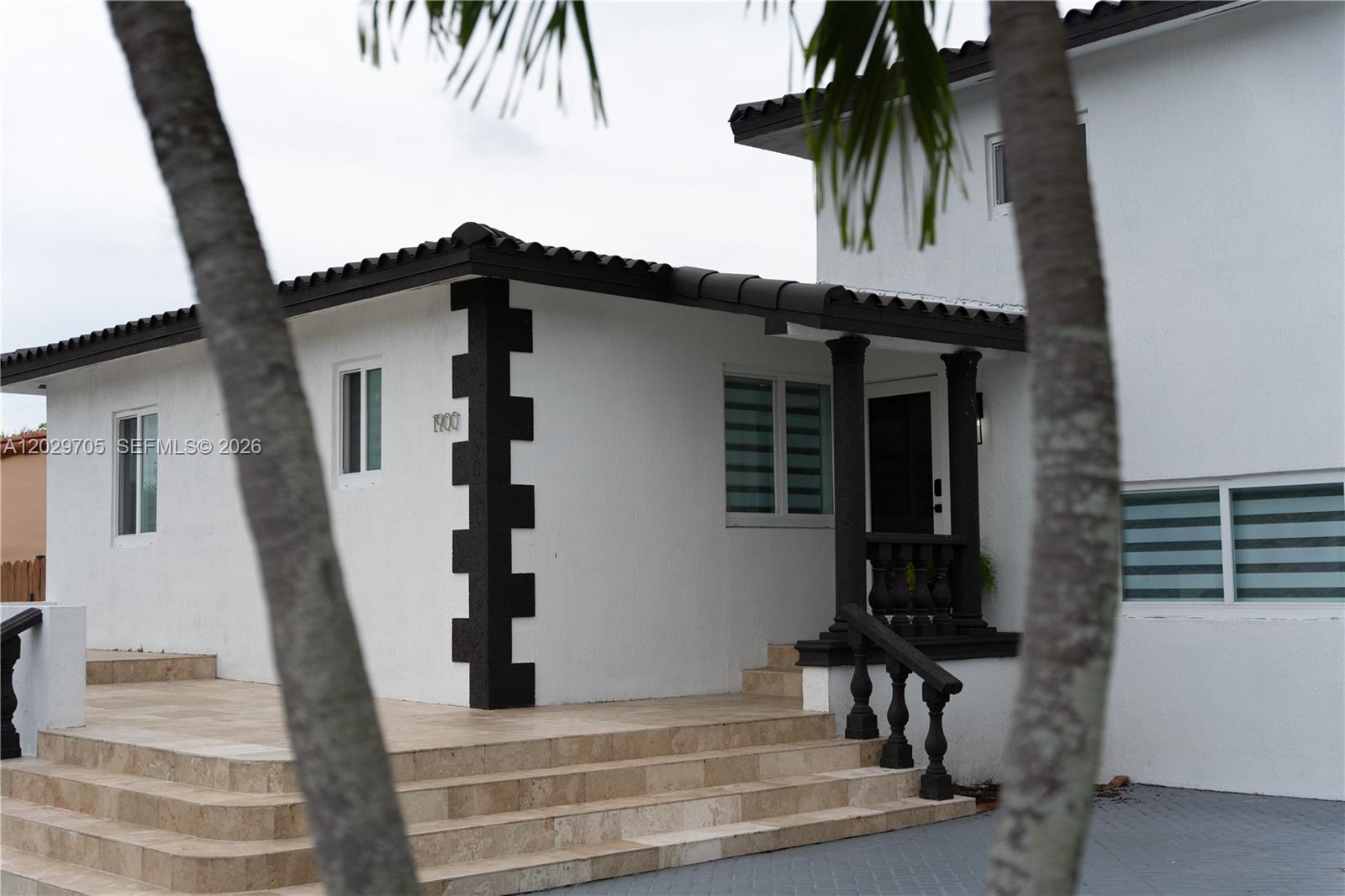 The exterior of a white house features a tiled porch, dark accents, and stone steps — 1900 SW 83rd Ave, Miami FL 33155, MIAMI, FL