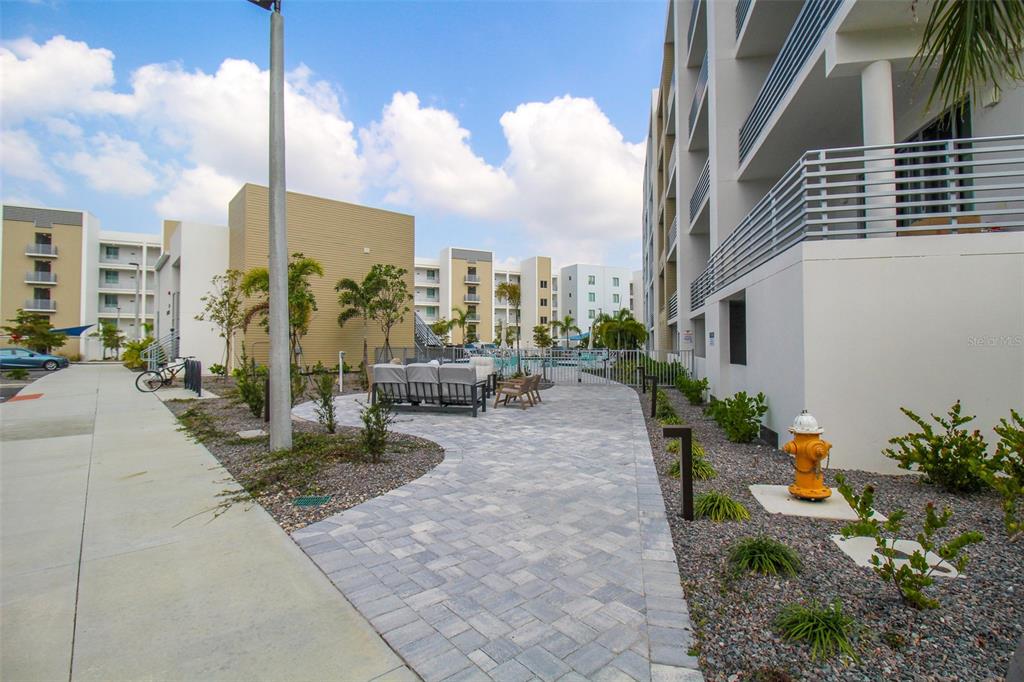 An outdoor patio area with seating and a fire hydrant beside a modern apartment building — 1703 N TAMIAMI TRAIL UNIT B406, SARASOTA, FL