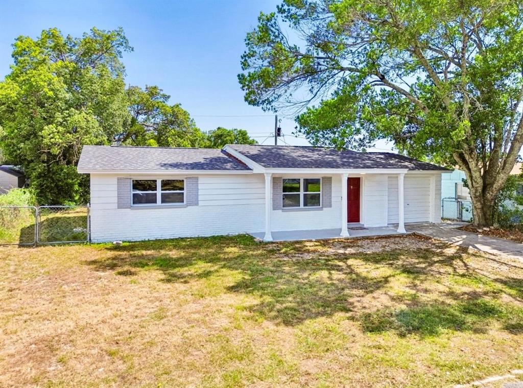 A single-story white brick house with a red front door and a covered porch — 5046 FARLEY DRIVE, HOLIDAY, FL