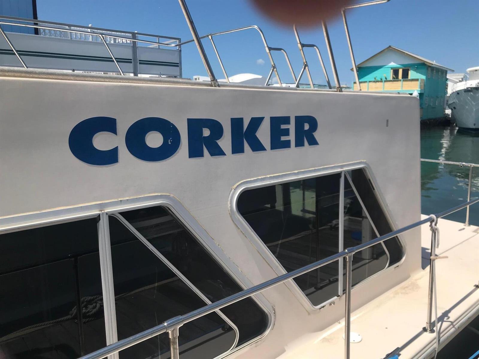 A white boat named CORKER is docked near a teal house on the water — 1801 N Roosevelt Boulevard, Key West FL 33040, KEY WEST, FL