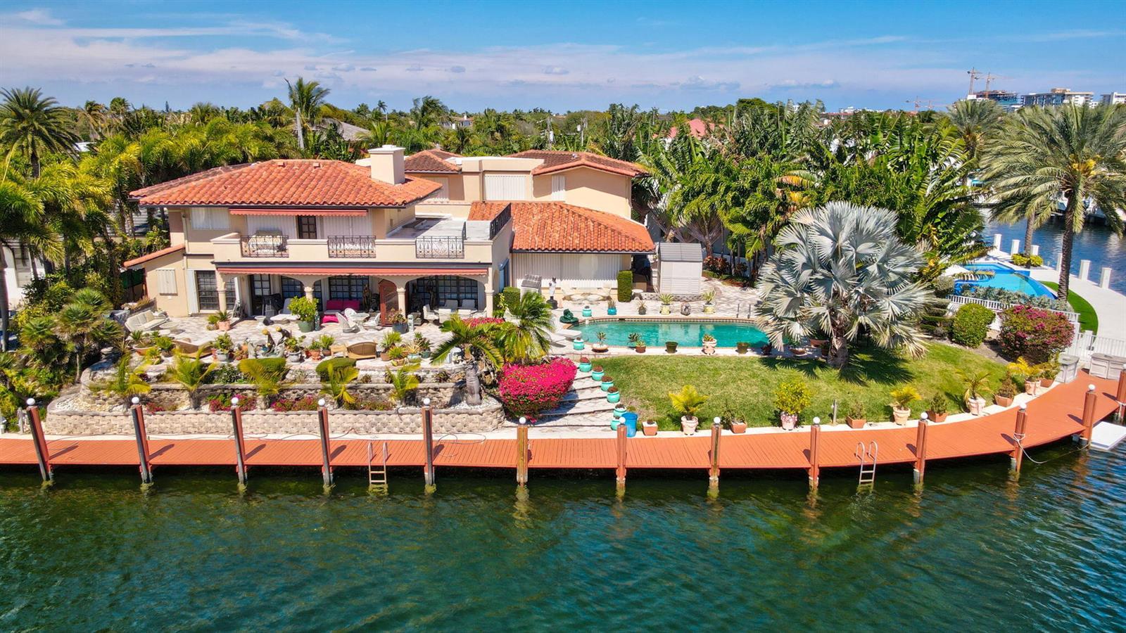An aerial view of a waterfront house with a swimming pool, patio, and wooden dock — 2850 NE 44th Street, Lighthouse Point FL 33064, LIGHTHOUSE POINT, FL