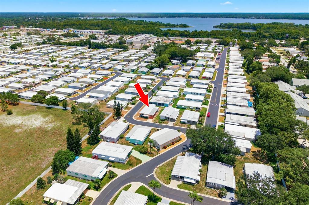 A light-colored mobile home with a carport and a parked SUV sits on a lot — 39820 US HIGHWAY 19 N UNIT 67, TARPON SPRINGS, FL