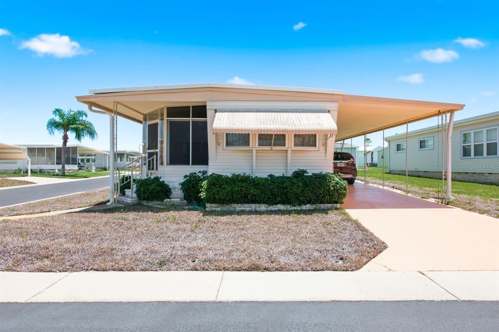 An aerial view shows a manufactured home community with a red arrow pointing to a house — 39820 US HIGHWAY 19 N UNIT 67, TARPON SPRINGS, FL