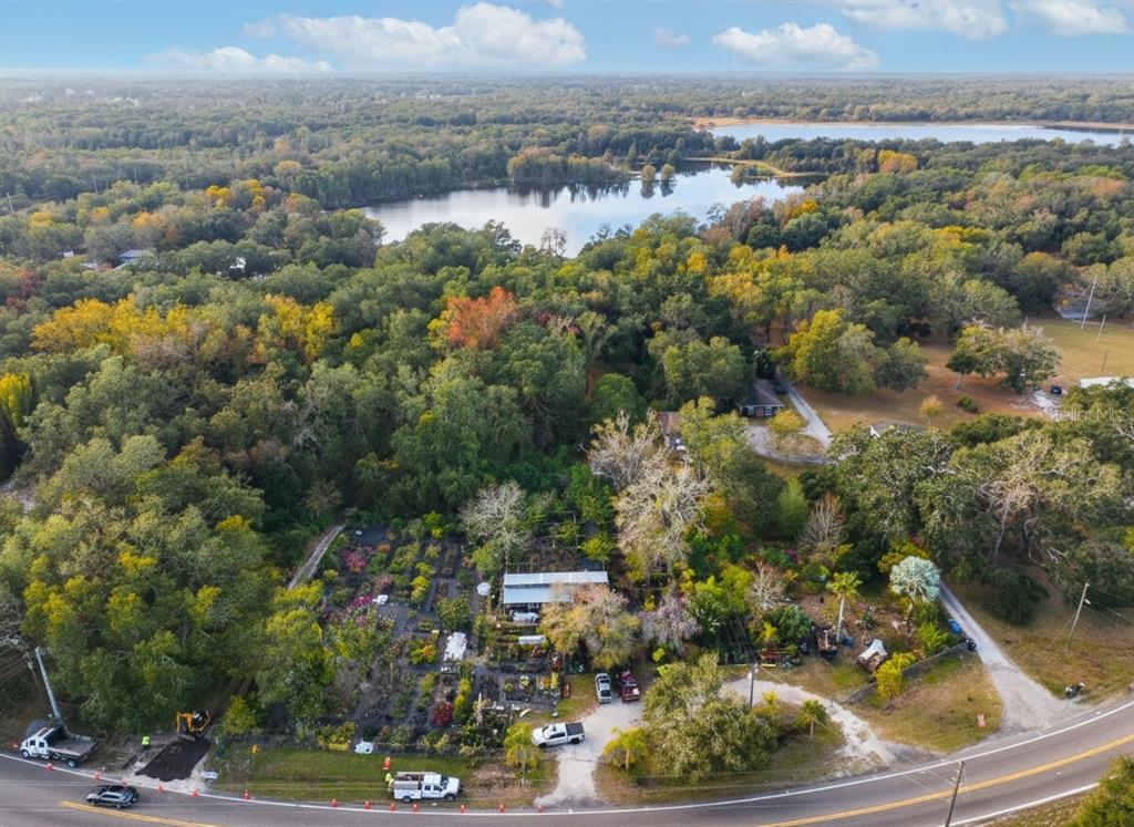 An aerial view shows a property with a nursery, a small building, and a lake — 9906 GUNN HIGHWAY, ODESSA, FL