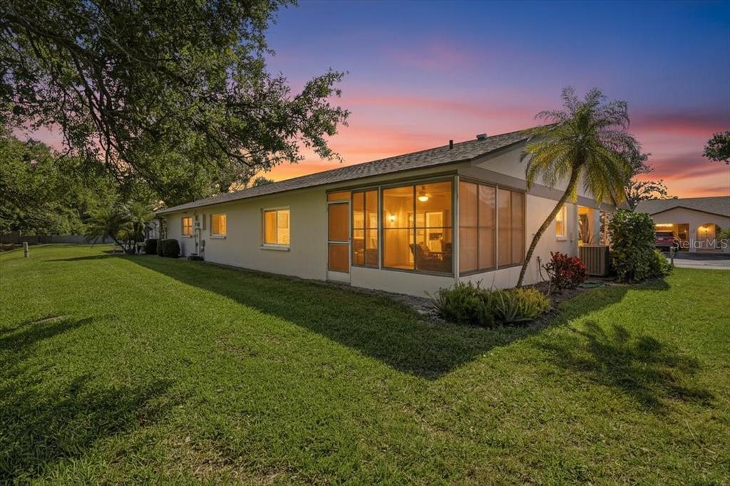 A single-story house with a screened-in porch and a palm tree at sunset — 3759 COLLINS STREET UNIT 711, SARASOTA, FL