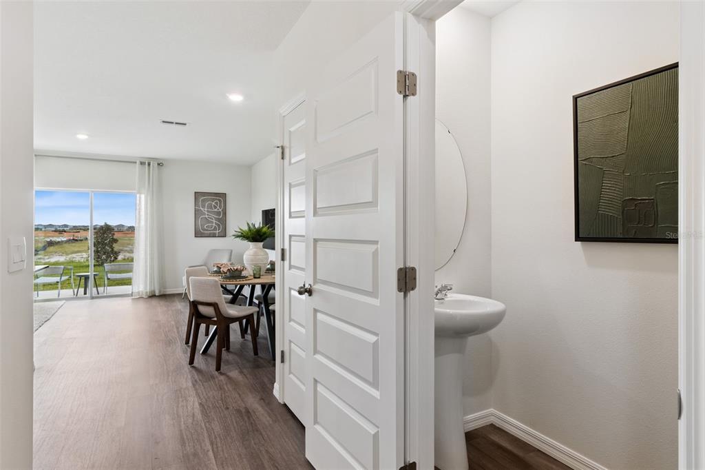 A view from a small powder room looking into a dining area with sliding doors — 4290 BUTTERSCOTCH CIRCLE, LAKELAND, FL