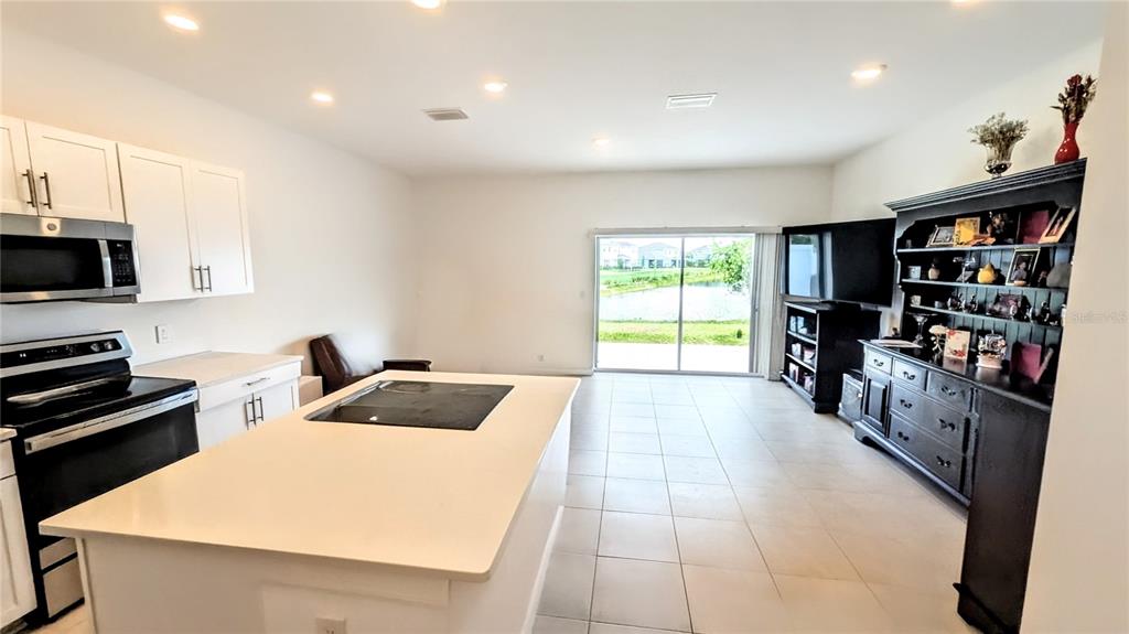 A kitchen with white cabinets, stainless steel appliances, and a large central island — 5686 ARCHIPELAGO STREET, NOKOMIS, FL