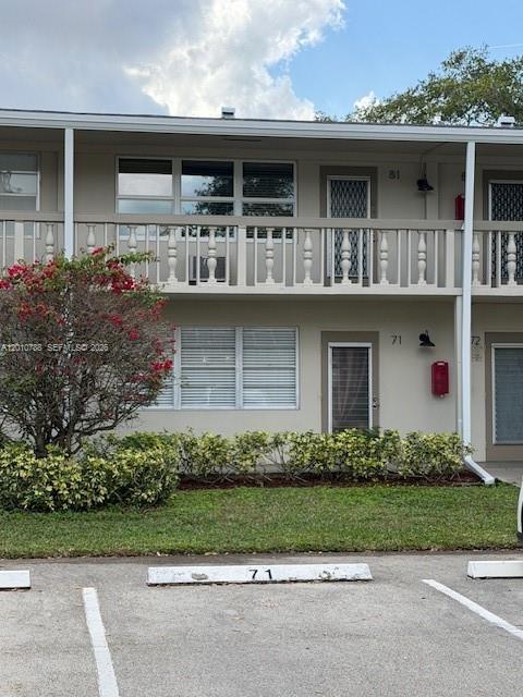 A two-story apartment building exterior features a balcony, white railings, and numbered unit doors — 71 Tilford D # 71, Deerfield Beach FL 33442, DEERFIELD BEACH, FL