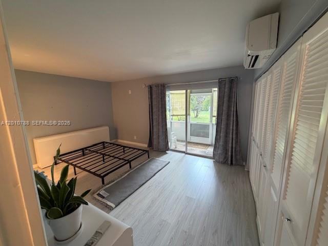 A bedroom features light wood-look flooring, a metal bed frame, and white louvered closet doors — 71 Tilford D # 71, Deerfield Beach FL 33442, DEERFIELD BEACH, FL