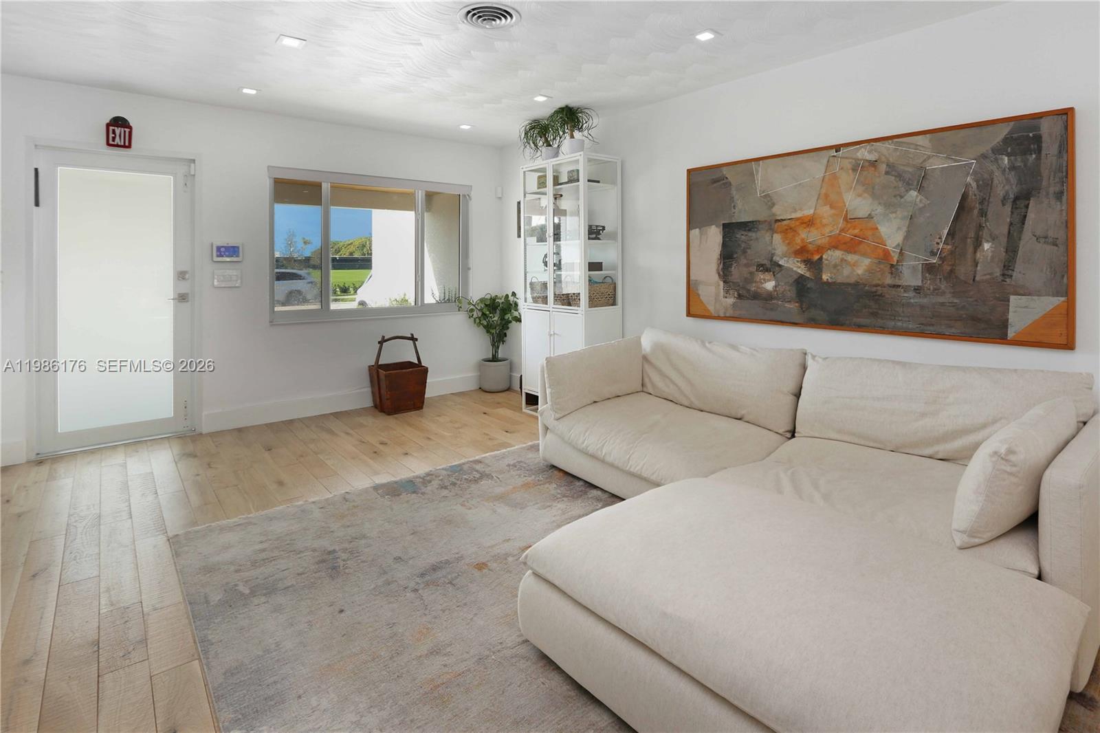 A living room features a white sectional sofa, a large abstract painting, and light flooring — 1523 Johnson St, Hollywood FL 33020, HOLLYWOOD, FL