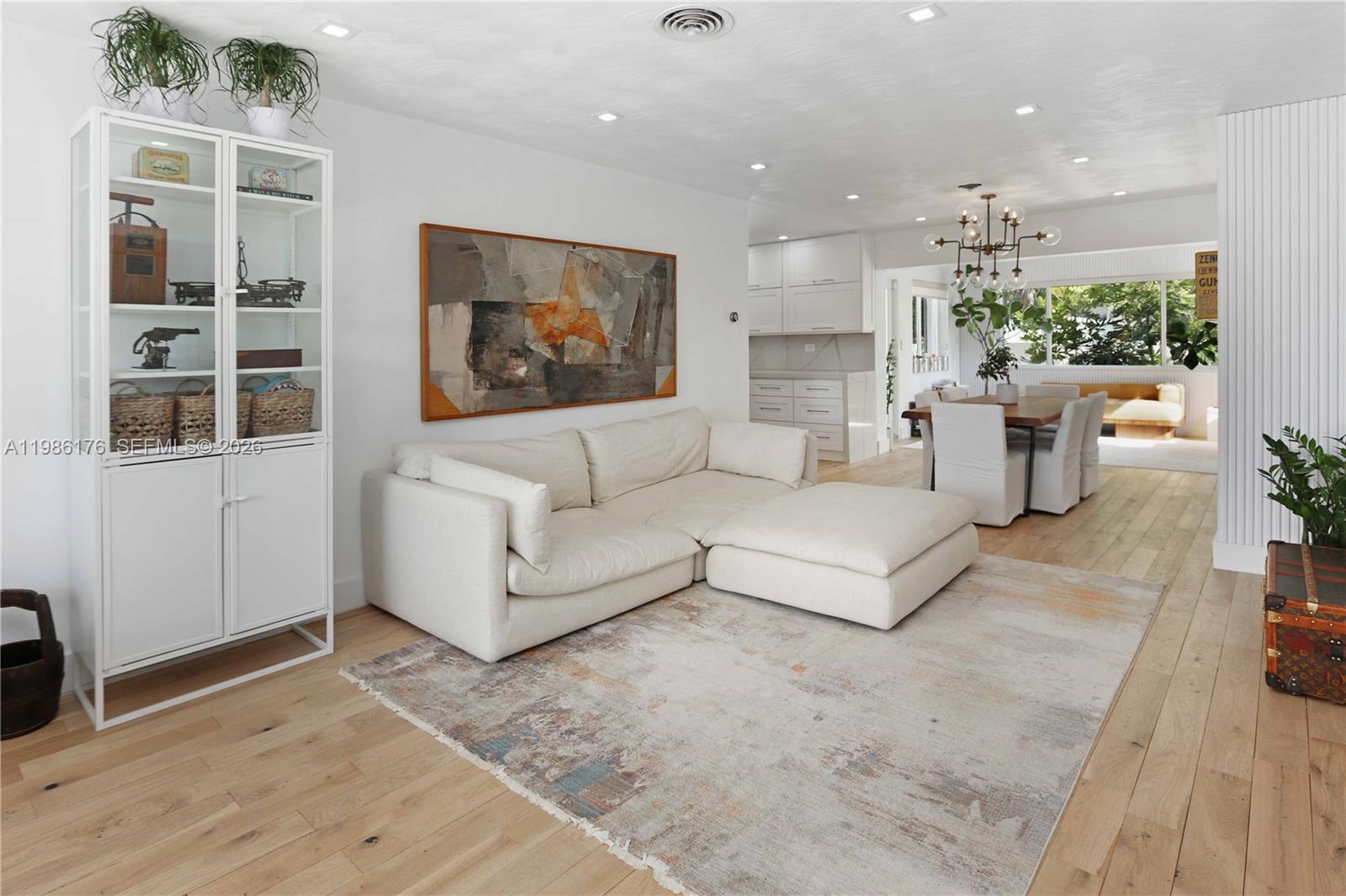 A living room features a white sectional sofa, a large area rug, and a dining area — 1523 Johnson St, Hollywood FL 33020, HOLLYWOOD, FL