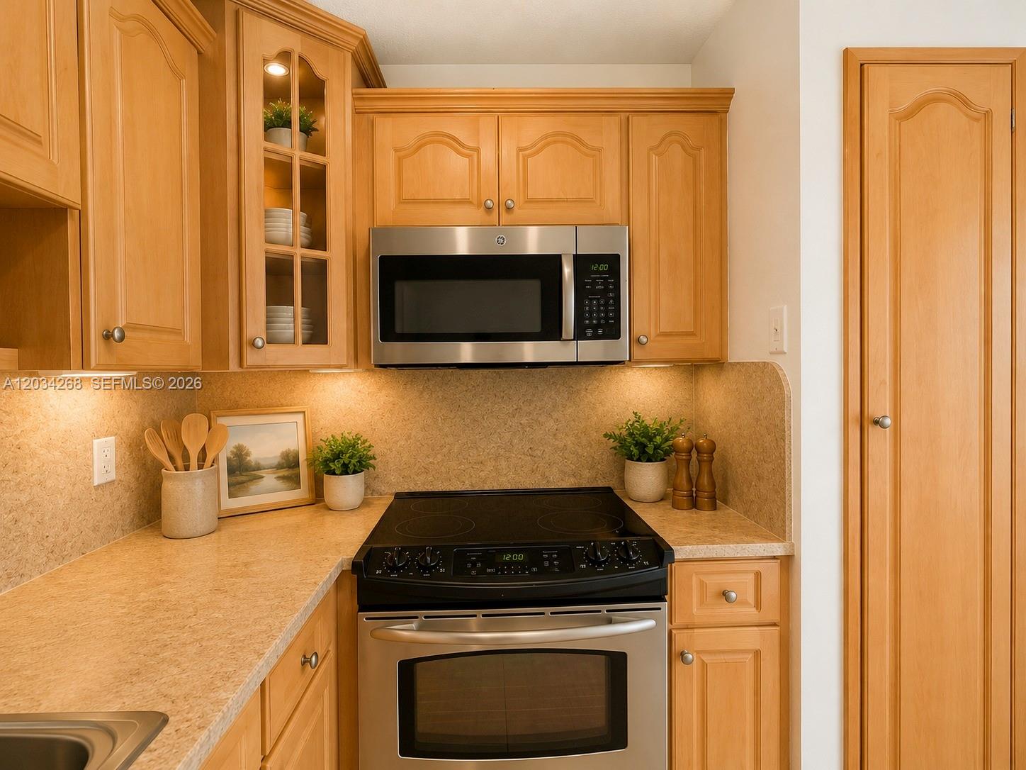 A kitchen features light wood cabinets, stainless steel appliances, and tan laminate countertops — 3041 W 76th St # 108, Hialeah FL 33018, HIALEAH, FL