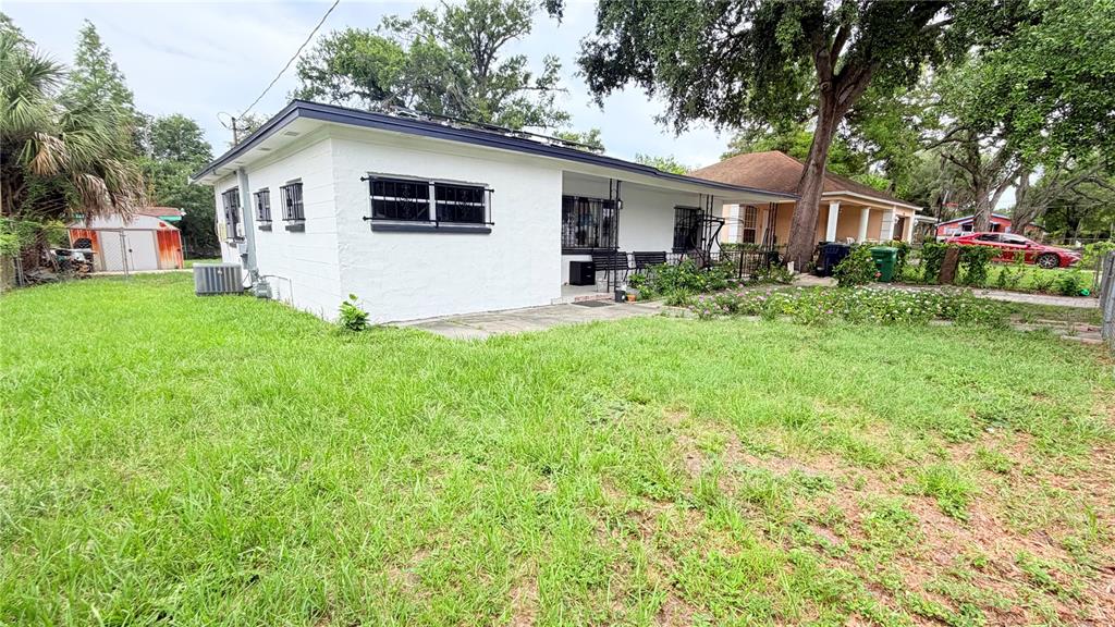 A white, single-story house with a flat roof and security bars on the windows — 1709 E NORTH BAY STREET, TAMPA, FL