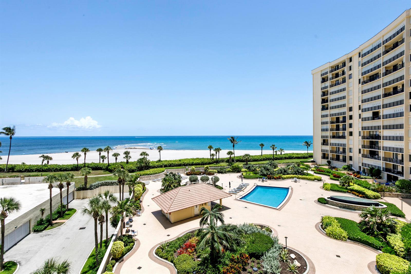 An elevated view of a beachside condominium complex featuring a swimming pool and landscaped grounds — 300 Ocean Trail Way # 510, Jupiter FL 33477, JUPITER, FL