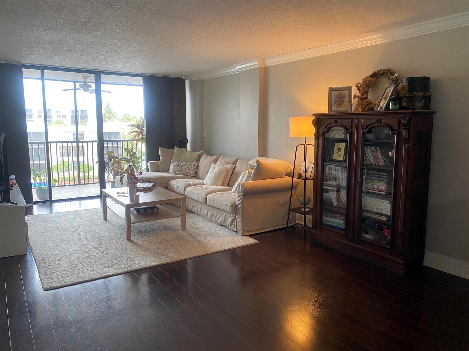A living room features a beige sectional sofa, a wooden display cabinet, and a balcony view — 9 Royal Palm Way # 403, Boca Raton FL 33432, BOCA RATON, FL