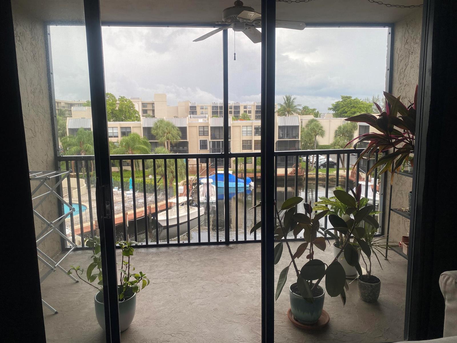 A screened-in balcony overlooks a canal with boats and a multi-story apartment complex — 9 Royal Palm Way # 403, Boca Raton FL 33432, BOCA RATON, FL