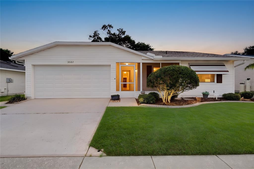 A single-story house with white siding, a two-car garage, and a front lawn — 3537 HIGHLAND FAIRWAYS BOULEVARD, LAKELAND, FL