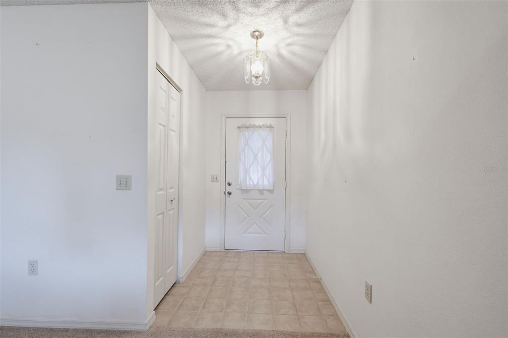 A tiled entryway features a white front door, a closet, and a ceiling light fixture — 3537 HIGHLAND FAIRWAYS BOULEVARD, LAKELAND, FL