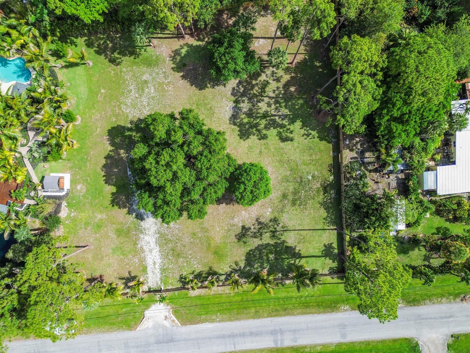 An aerial view shows a large, grassy residential lot with several trees and a driveway — 13530 42nd Road N, West Palm Beach FL 33411, WEST PALM BEACH, FL