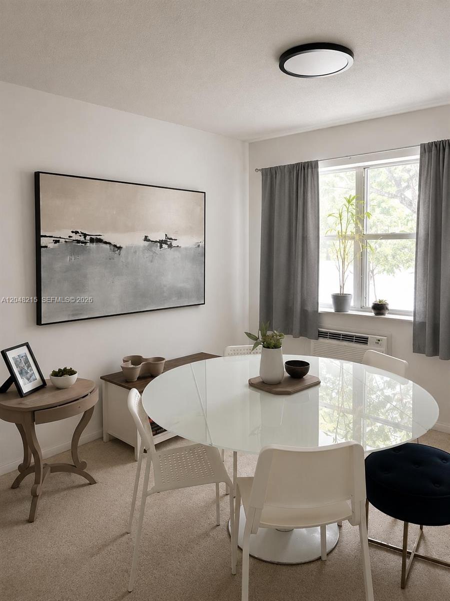 A dining area features a round glass table, white chairs, and abstract wall art — 3501 Van Buren St # 6, Hollywood FL 33021, HOLLYWOOD, FL