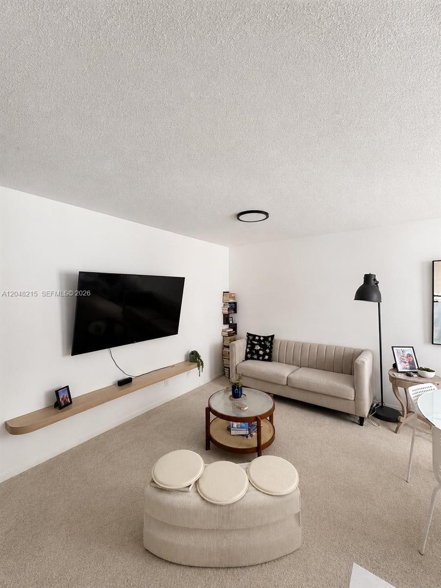 A living room features a wall-mounted television, a floating shelf, a sofa, and a coffee table — 3501 Van Buren St # 6, Hollywood FL 33021, HOLLYWOOD, FL
