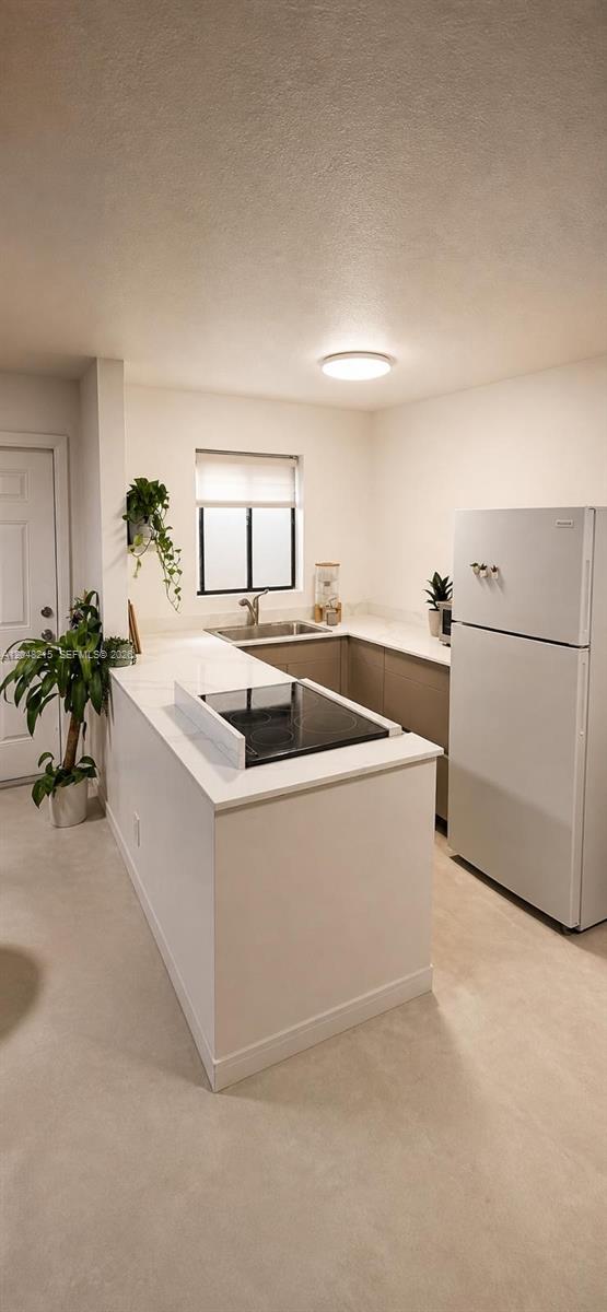A modern kitchen features white countertops, a cooktop island, and light-colored cabinetry — 3501 Van Buren St # 6, Hollywood FL 33021, HOLLYWOOD, FL