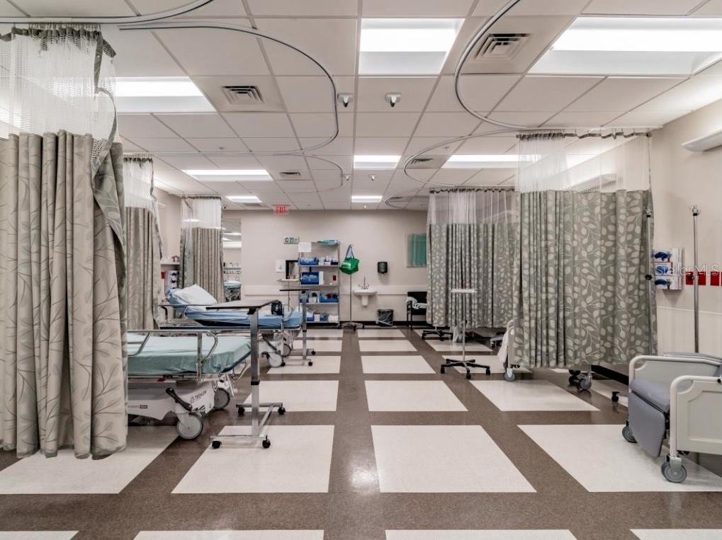A medical examination room features multiple hospital beds, privacy curtains, and a tiled floor — 4703 N ARMENIA AVENUE, TAMPA, FL