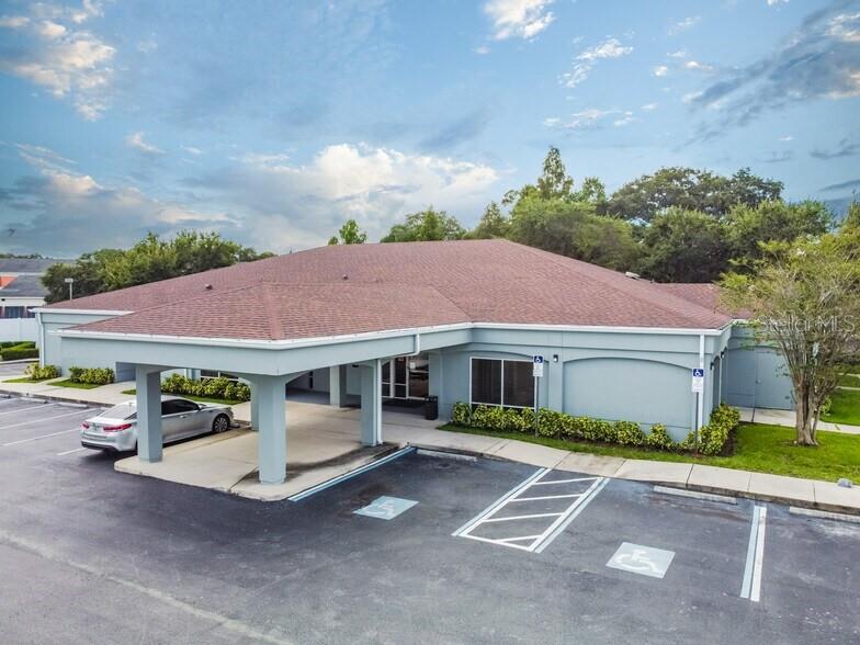 An exterior view of a single-story commercial building with a covered entrance and parking lot — 4703 N ARMENIA AVENUE, TAMPA, FL