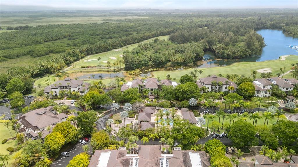 An aerial view shows a resort complex with multiple buildings, swimming pools, and a golf course — 8164 LAS VERANDAS AT BAHIA BEACH RESORT, RIO GRANDE, PR