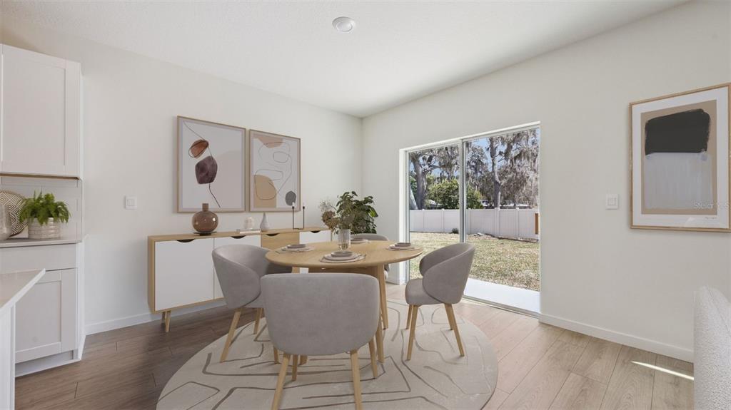 A dining area features a round wooden table, four gray chairs, and a sliding glass door — 1120 GULL DRIVE, APOPKA, FL