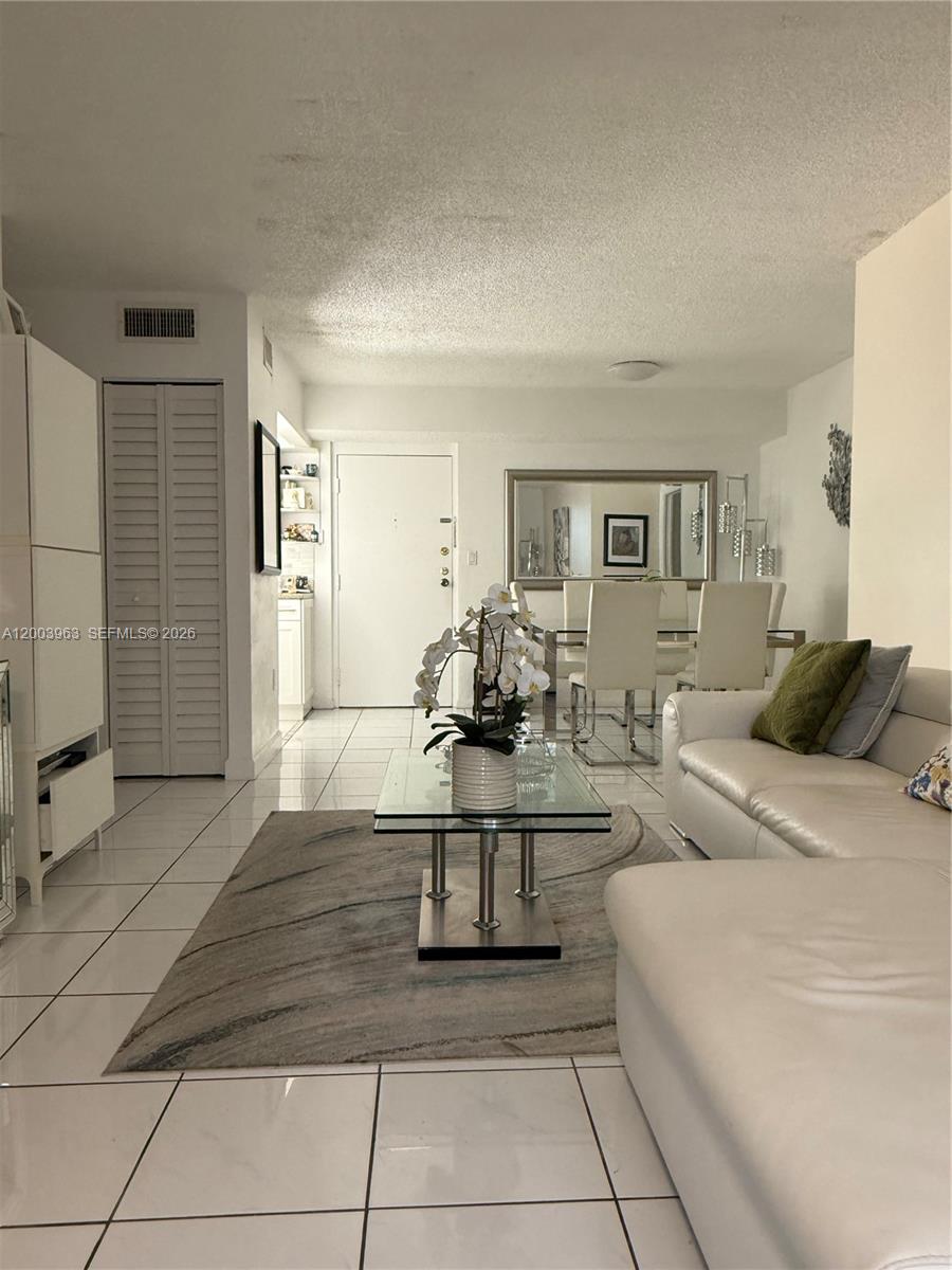 A living room features white tile floors, a white sofa, and a glass coffee table — 5033 NW 7th St # 312, Miami FL 33126, MIAMI, FL
