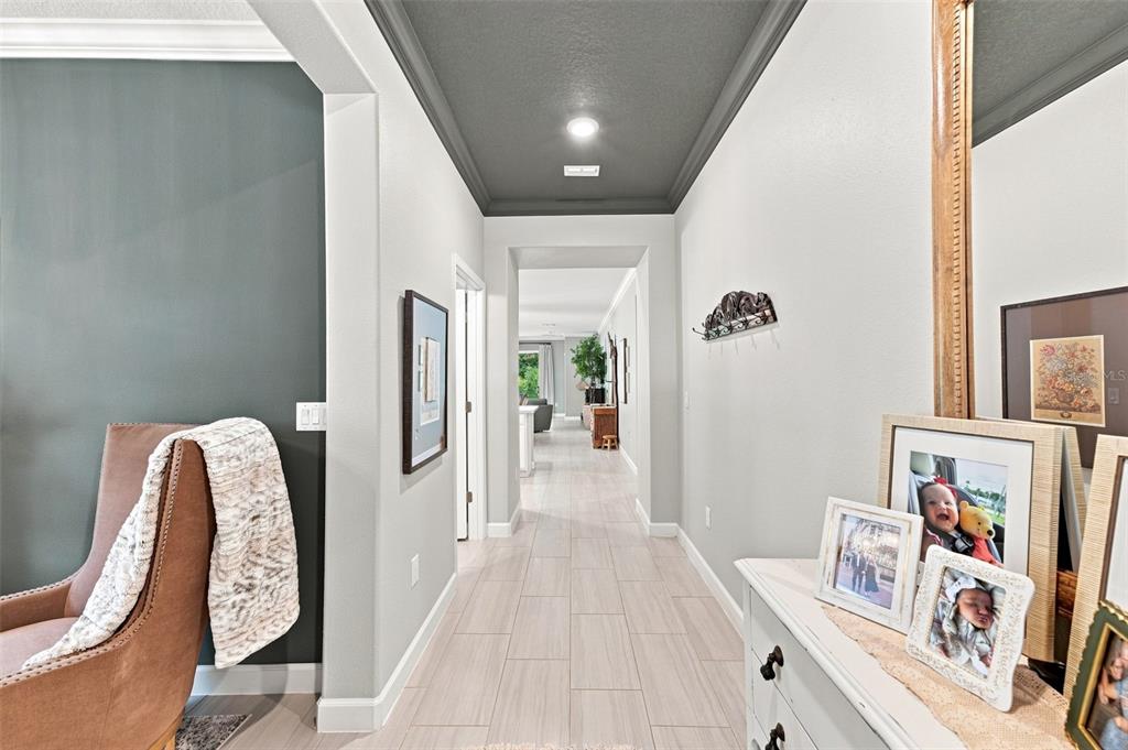 A hallway with light tile floors leads toward a living area under a dark ceiling — 5231 WINDY GROVE DRIVE, WIMAUMA, FL