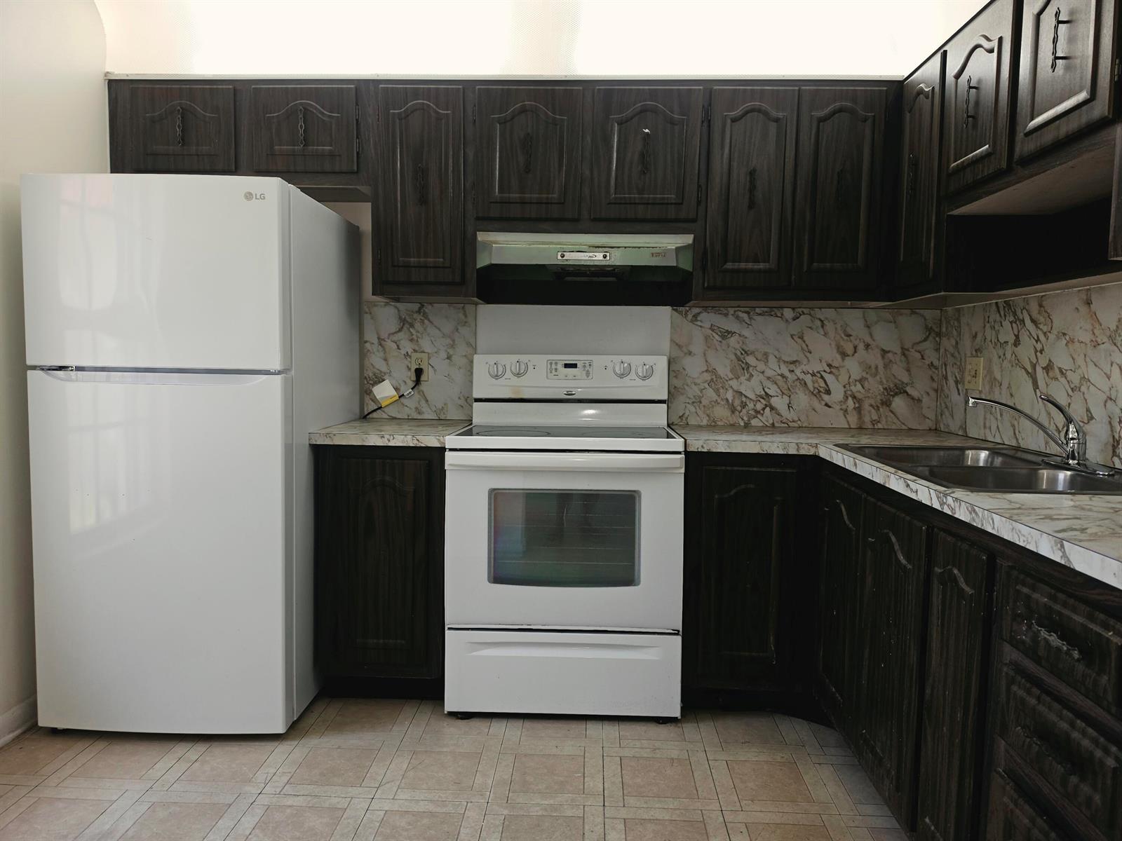 A kitchen features dark wood cabinets, white appliances, and a marble-patterned laminate countertop and backsplash — 713 Nantucket Circle # B, Lake Worth FL 33467, LAKE WORTH, FL