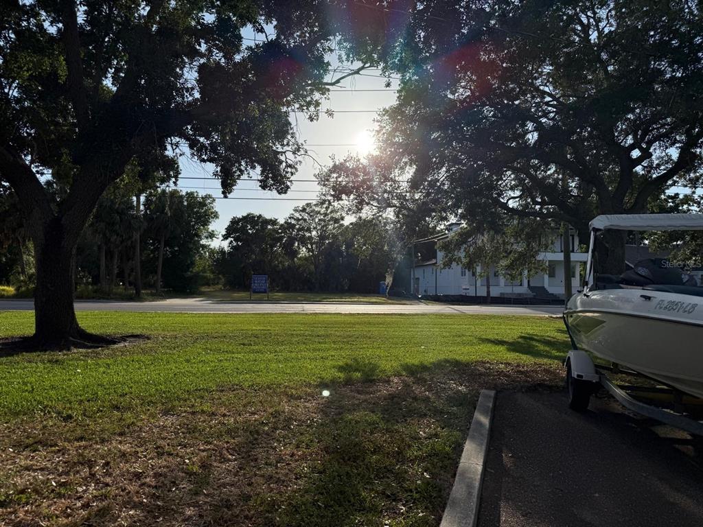 A grassy lawn with a boat on a trailer sits in front of a road — 3733 6TH STREET S, ST PETERSBURG, FL