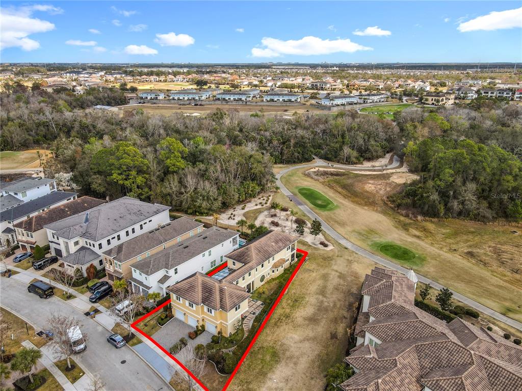 An aerial view shows a two-story house with a red outline on a golf course — 917 DESERT MOUNTAIN COURT, REUNION, FL