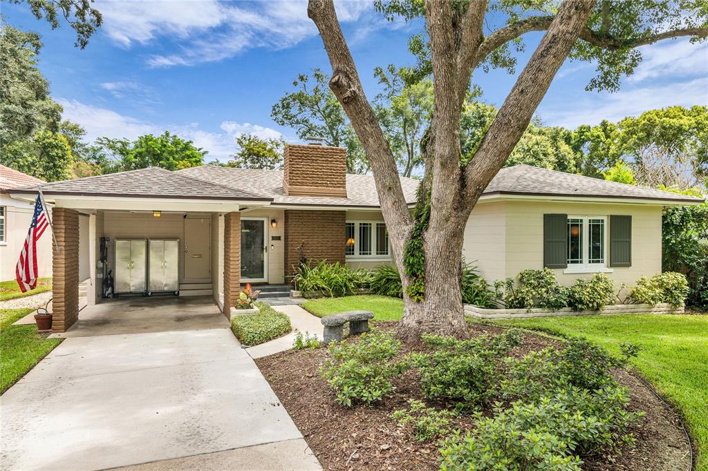 A single-story house with a carport, brick chimney, and a large tree in the front yard — 1215 DELANEY PARK DRIVE, ORLANDO, FL